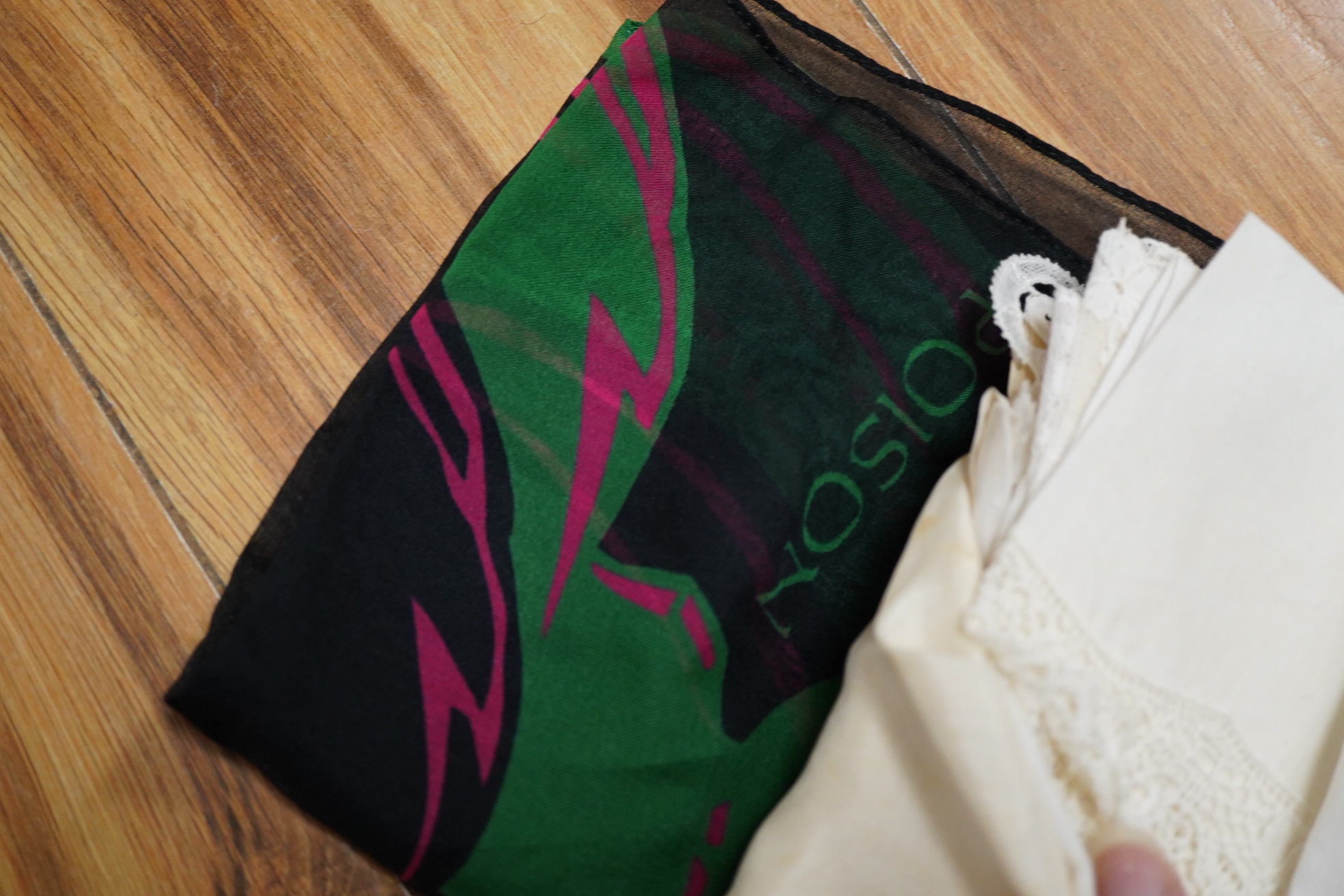 A collection of hankies, including a silk circa 1985 Christian Dior silk advertising ‘Poison’ hanky, Honiton bobbin lace and four other bobbin lace hankies, mixed machine lace hankies and 1930’s printed hankies. 33cm squ